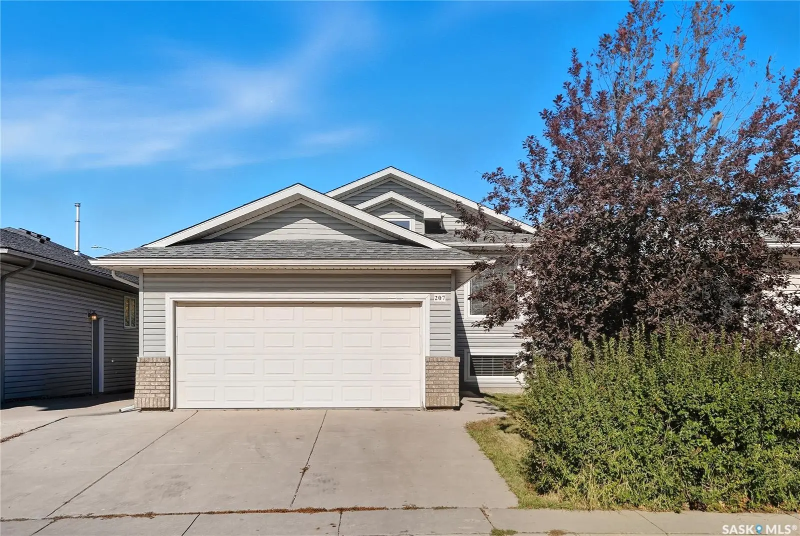 Exterior photo of 207 Buckwold Cove Saskatoon SK, a bi-level home with attached garage in Arbor Creek.